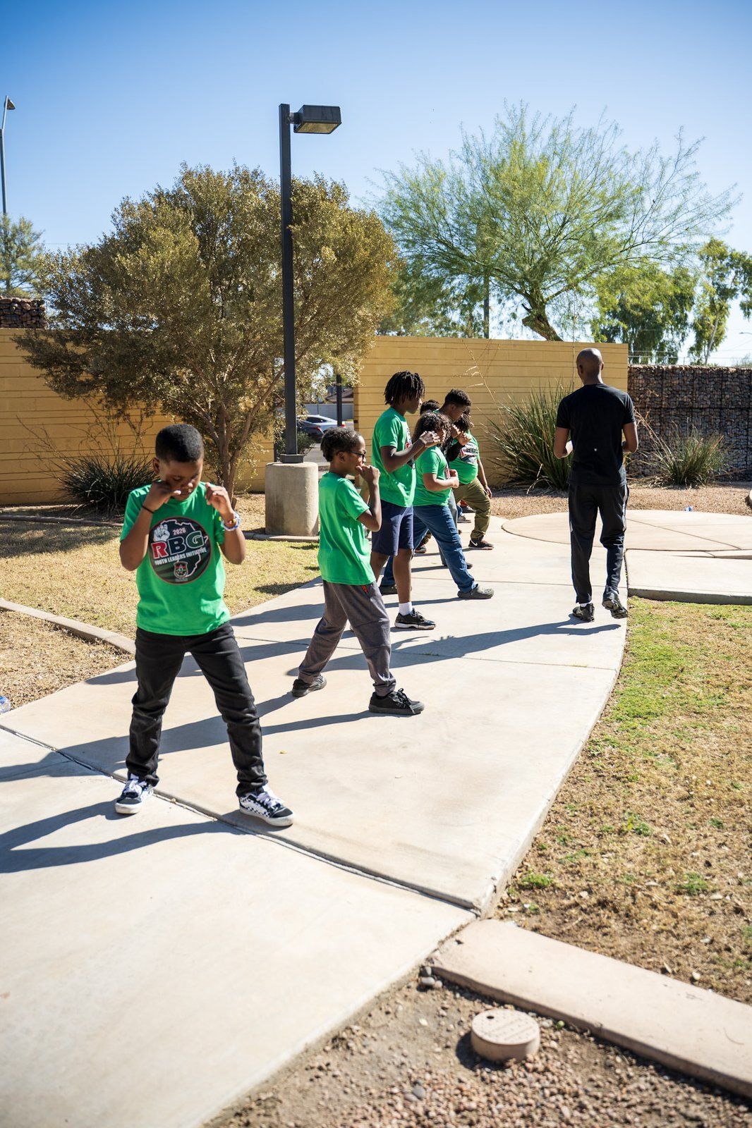 Young mentees walking together outdoors on a sunny afternoon