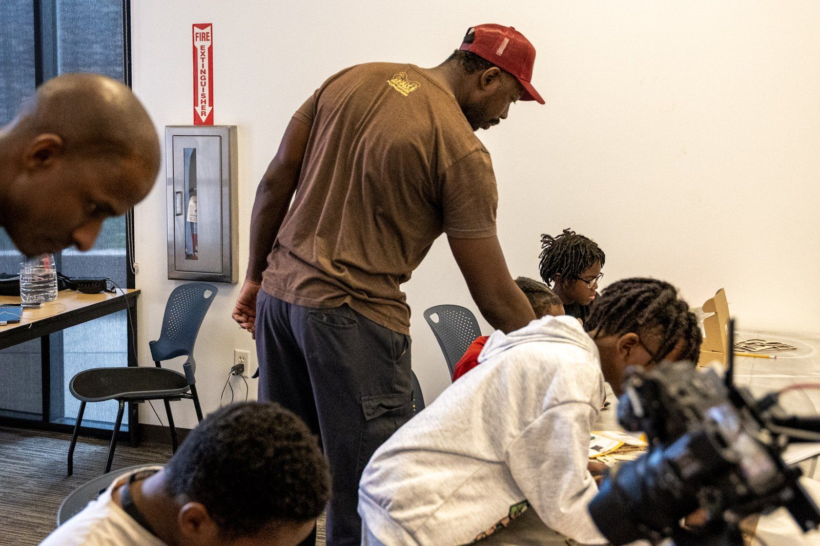 A mentor working alongside mentees at a build table