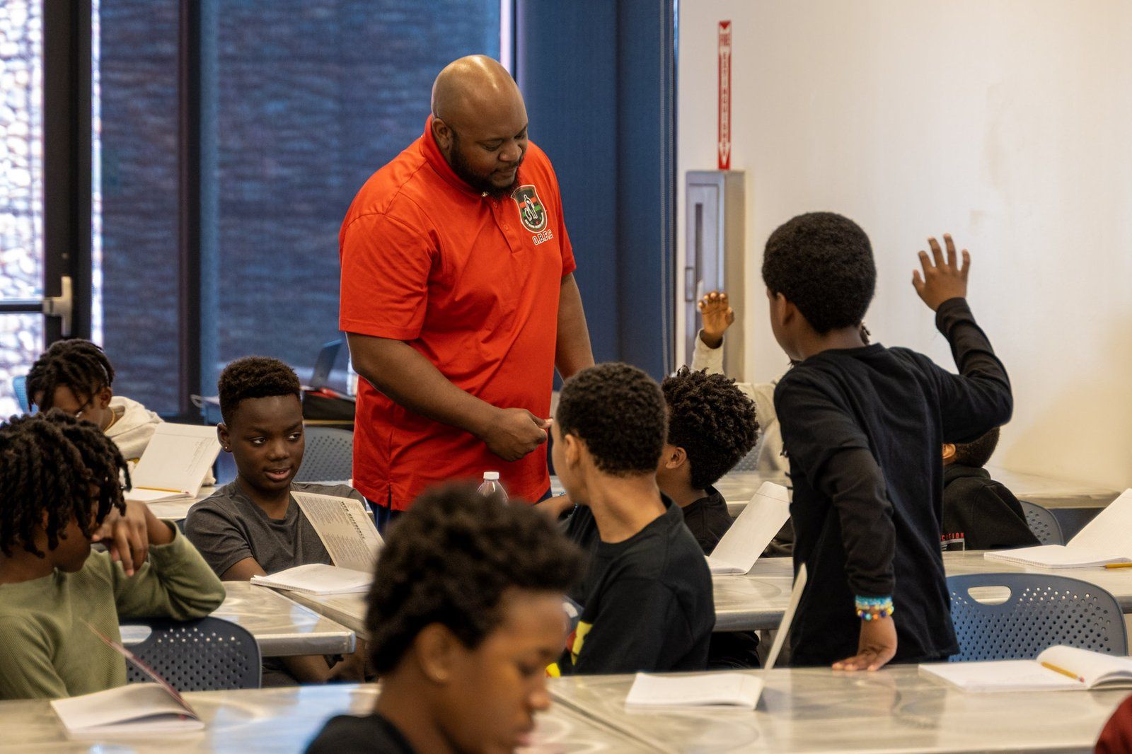 A mentor checking in with mentees during a table activity