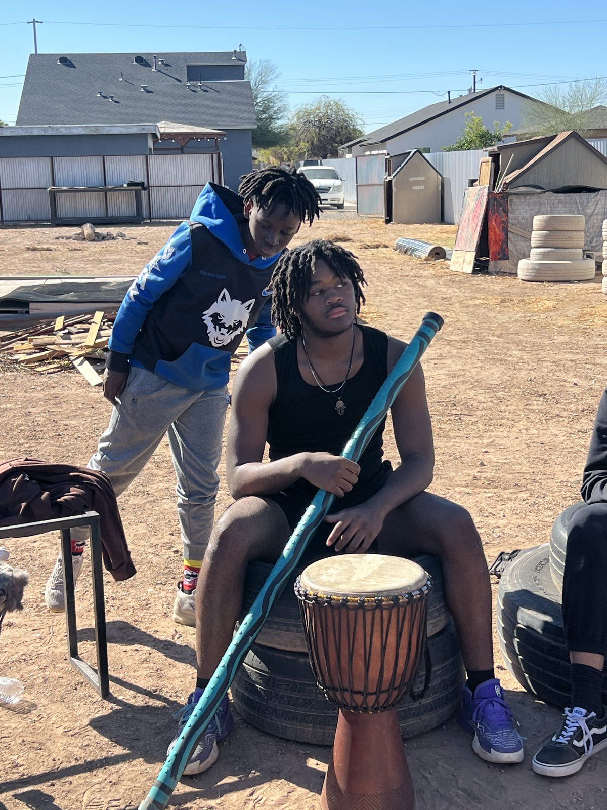 Mentees seated with drums during an outdoor drumming circle