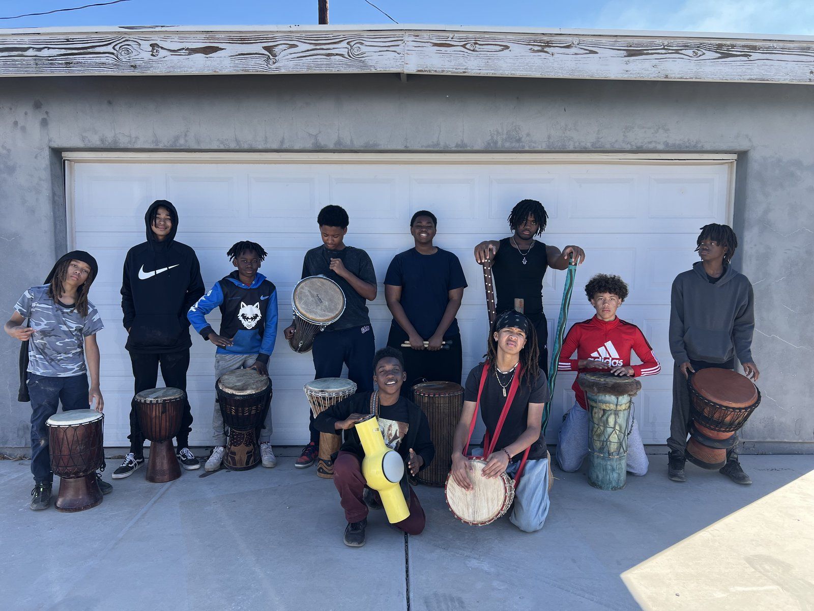 Mentees posed with djembe drums after a drumming session