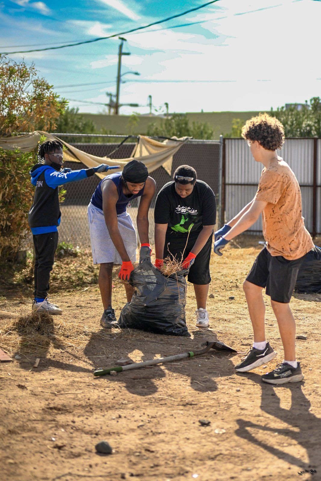 Mentees clearing brush during a community cleanup