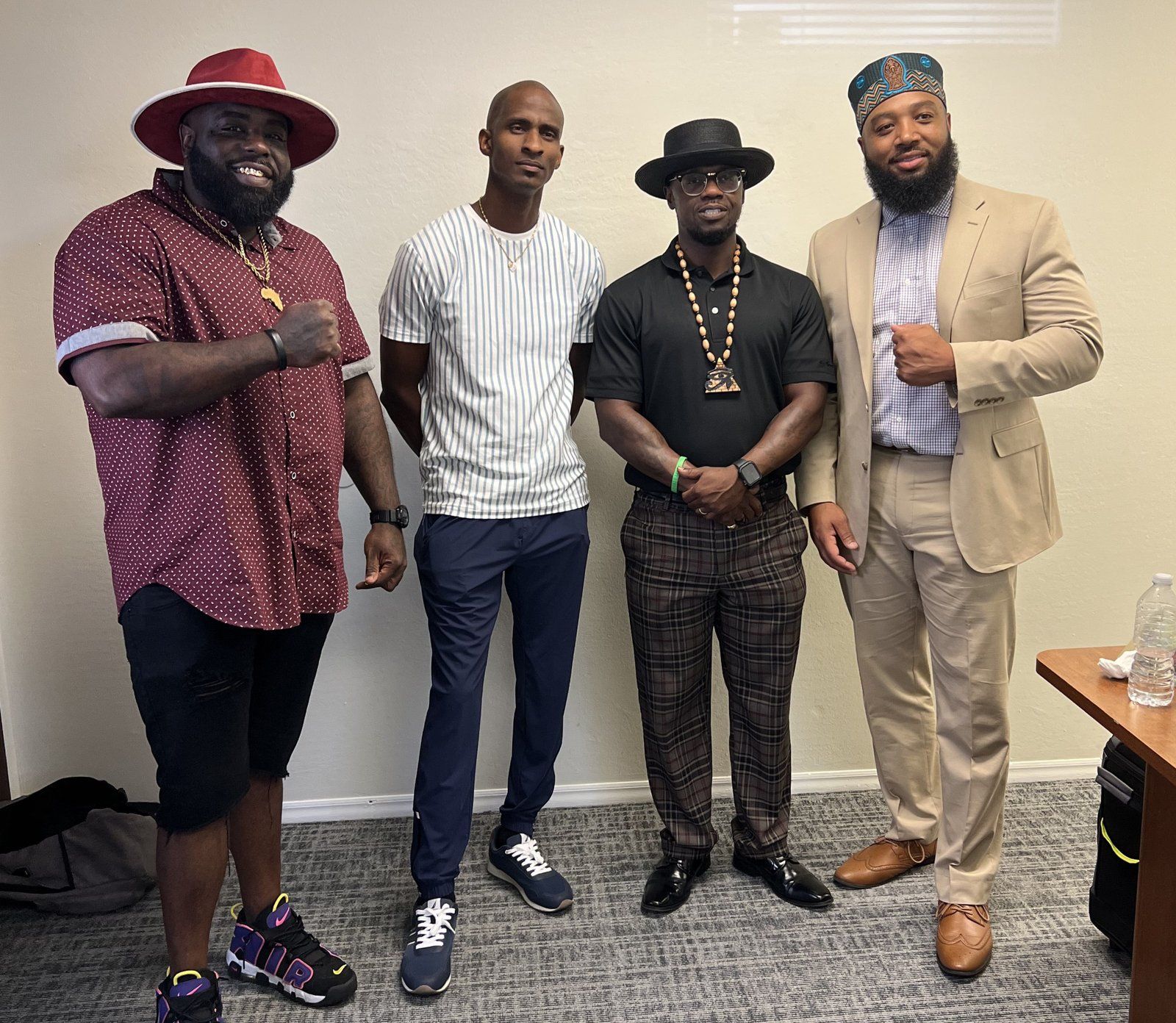 Four fathers posed together at a community program