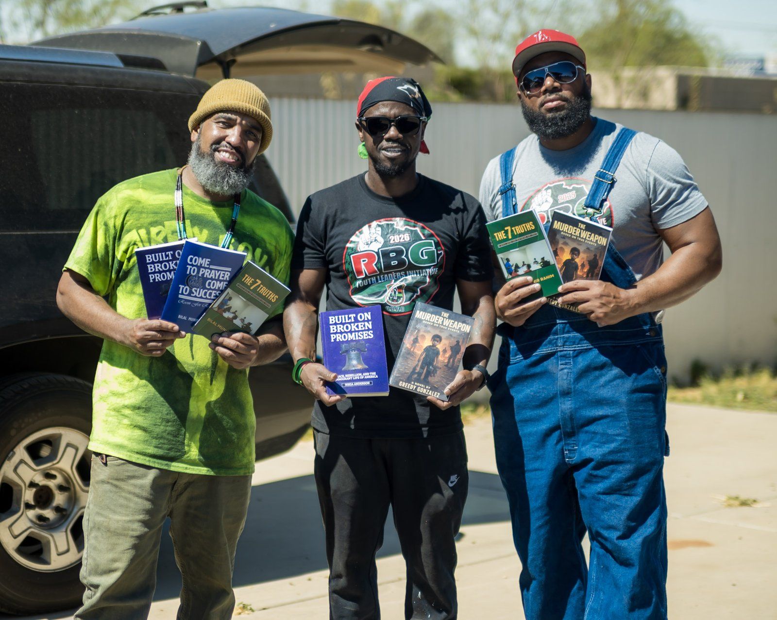 Mentors holding books at an outdoor event