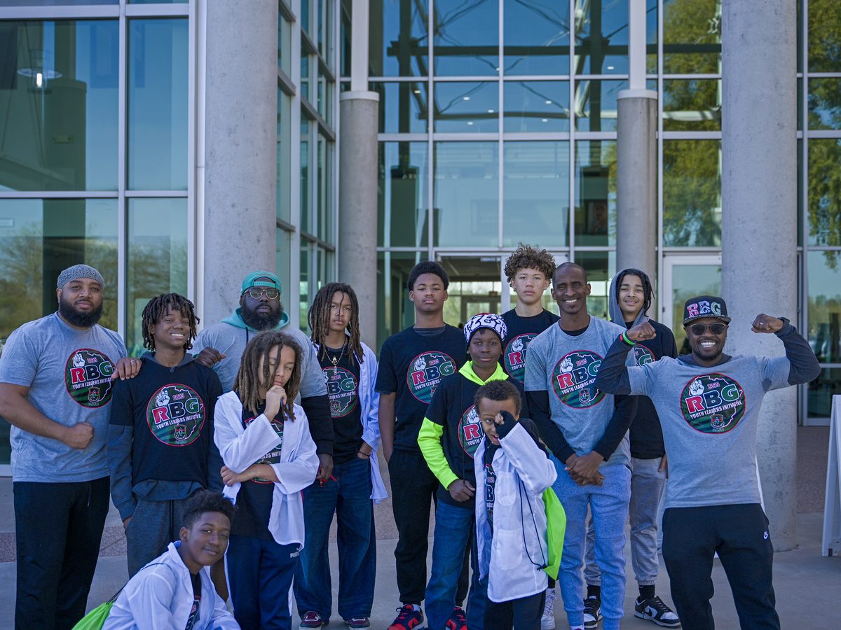Families, mentors and young people gathered outside a community event.