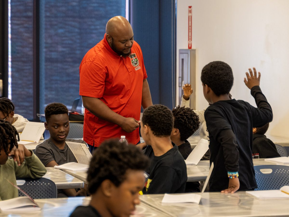 A mentor leads a classroom session with young men.